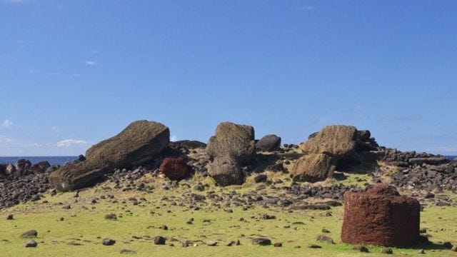 Ruins of toppled Moai statues from a collapsed society