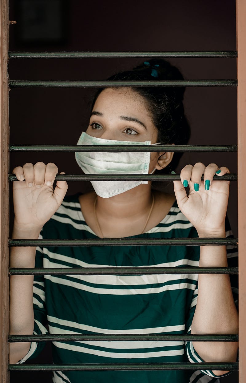 Woman in a striped shirt looking out a window